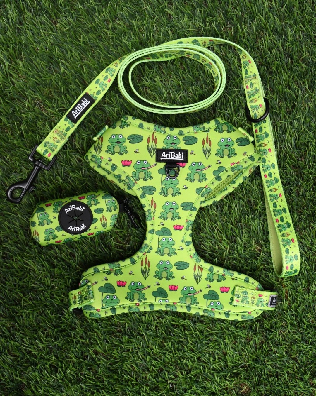 Conjunto de arnés ajustable con correa y portabolsas verde con dibujos de ranas de la colección Amazonas de la marca Aribabi.